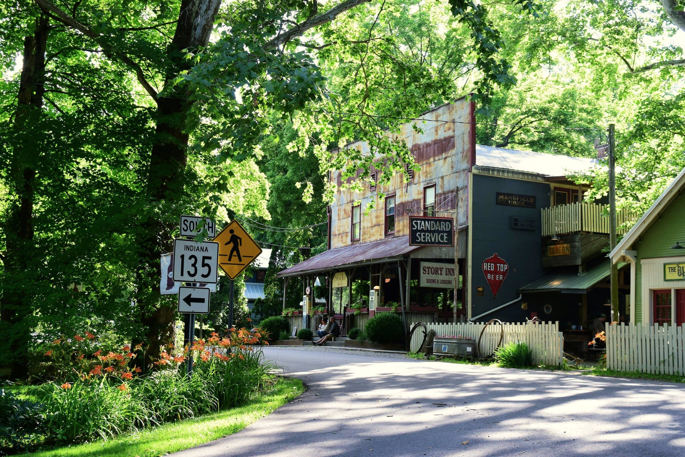 An Indiana 135 state road sign beside an old general store with a Standard Service sign in Story, Indiana.